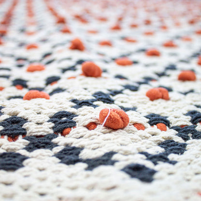 Tappeto intrecciato con nappe rosse e nere